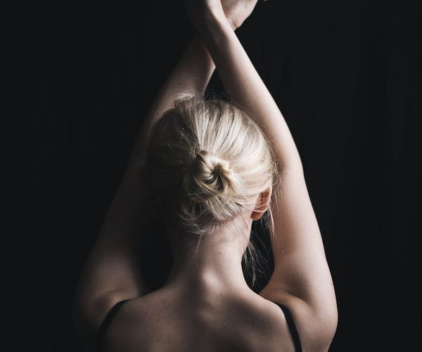 Silhouette of a person in a meditative pose against a dark background.